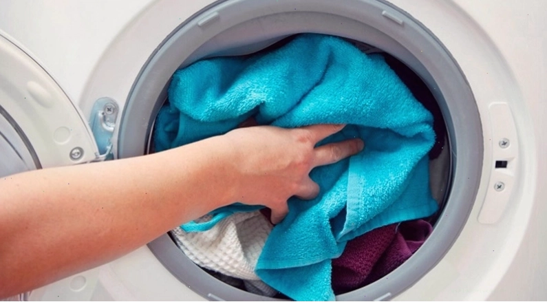 Cho quần áo vào lồng sấy của máy sấy Aqua