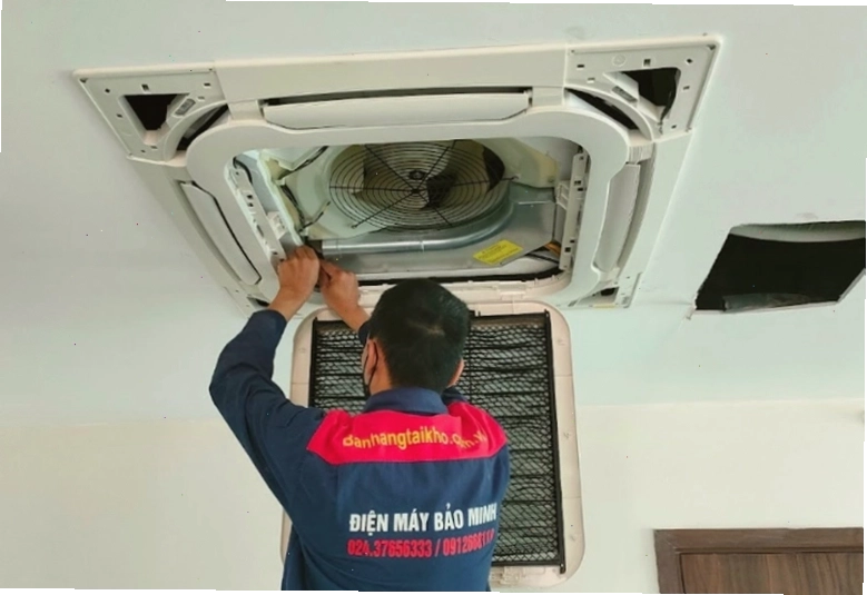 Kỹ thuật viên đang lắp đặt điều hòa âm trần