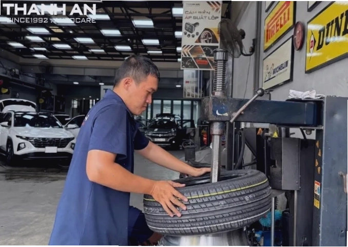 Kỹ thuật viên đang thực hiện quy trình thay lốp xe ô tô tại gara
