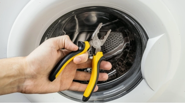 Kỹ thuật viên đang thực hiện thay ổ bi cho lồng máy giặt