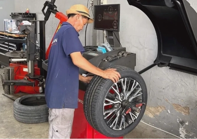 Kỹ thuật viên thực hiện cân bằng động lốp xe ô tô tại gara chuyên nghiệp
