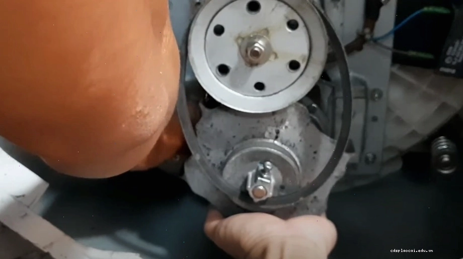 Tháo ốc vít ở hai bên máy giặt