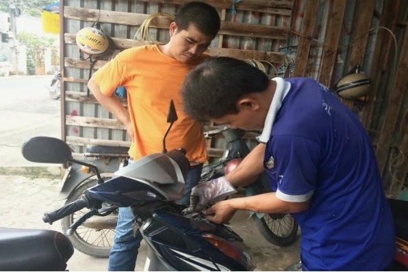 Thợ sửa xe đang thực hiện việc thay thế còi xe máy